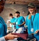 3 bénévoles en train de distribuer des vêtements