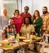 4 femmes et 3 hommes devant une table à manger